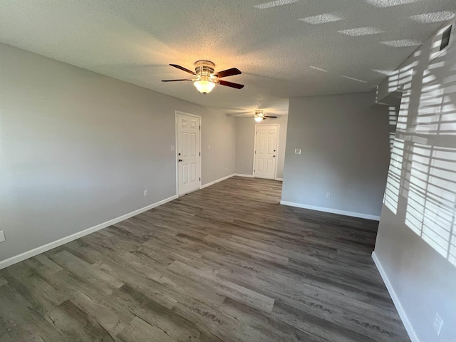 empty room featuring ceiling fan, dark hardwood / wood-style floors, and a textured ceiling