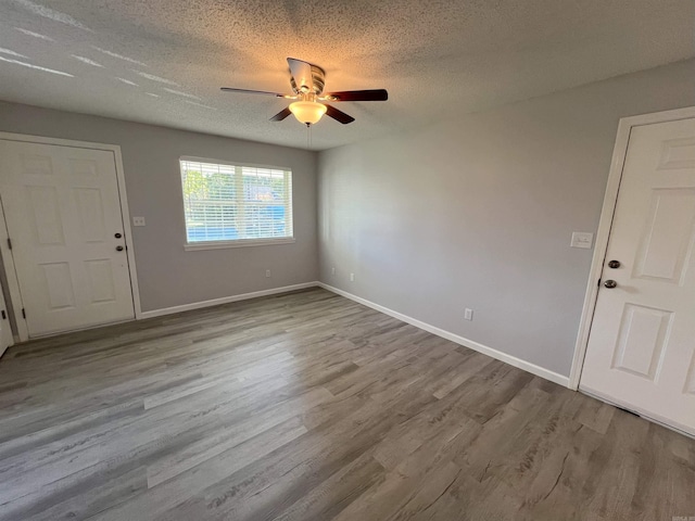 unfurnished room with a textured ceiling, ceiling fan, and light hardwood / wood-style flooring