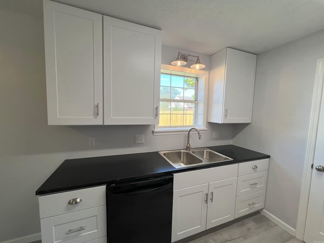 kitchen featuring a textured ceiling, white cabinets, sink, and dishwasher