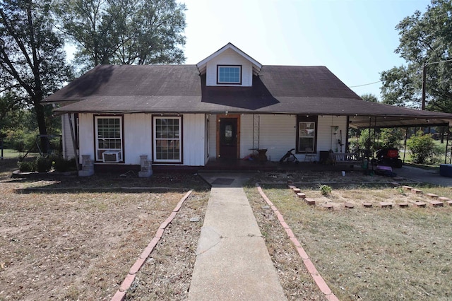 view of front of property featuring cooling unit, a front yard, covered porch, and a carport