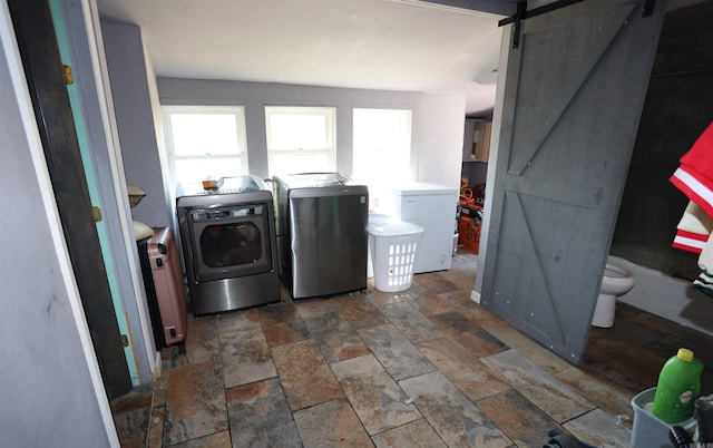 laundry room featuring independent washer and dryer and a barn door