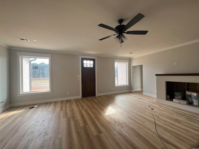 unfurnished living room with ceiling fan, crown molding, light hardwood / wood-style floors, and a wealth of natural light