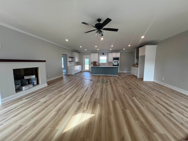 unfurnished living room with light wood-style floors, baseboards, a ceiling fan, and recessed lighting