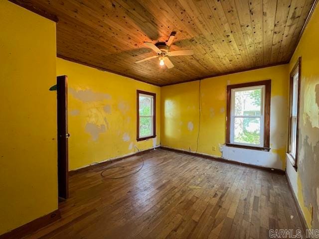 spare room featuring ceiling fan, dark wood-type flooring, and wood ceiling