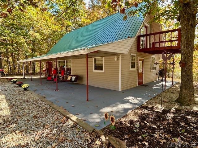 view of side of property featuring a balcony and a patio area