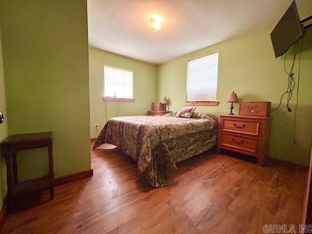 bedroom with dark hardwood / wood-style floors