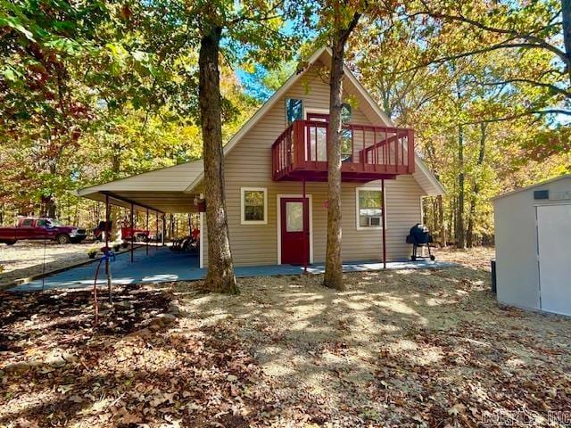 back of property featuring a wooden deck and a balcony