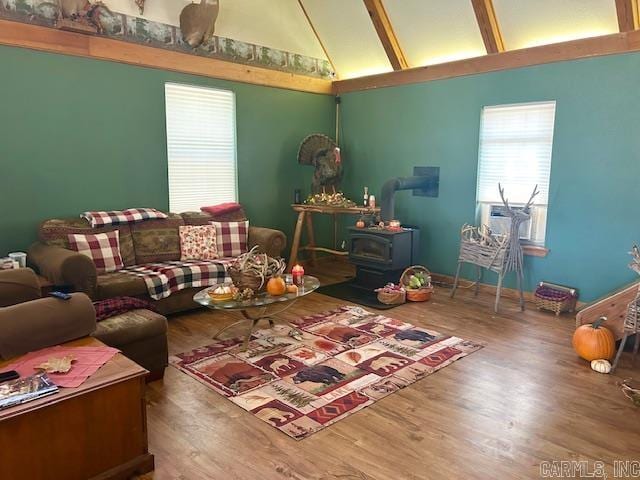 living room featuring a wood stove, high vaulted ceiling, and hardwood / wood-style floors