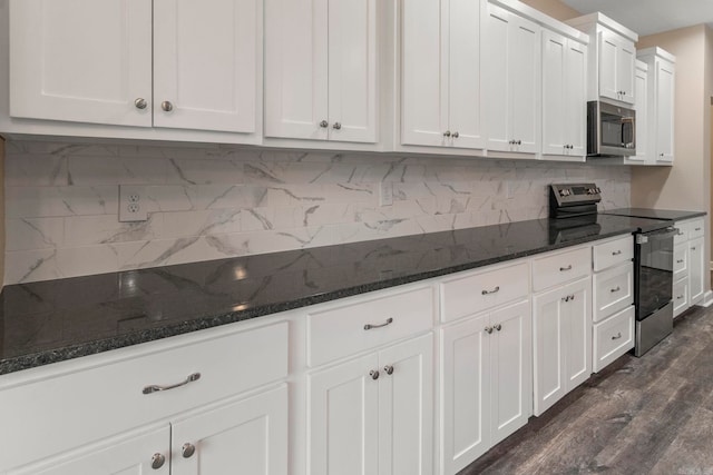 kitchen with backsplash, dark hardwood / wood-style flooring, white cabinets, and appliances with stainless steel finishes