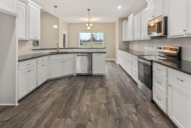 kitchen featuring decorative light fixtures, white cabinetry, sink, and appliances with stainless steel finishes