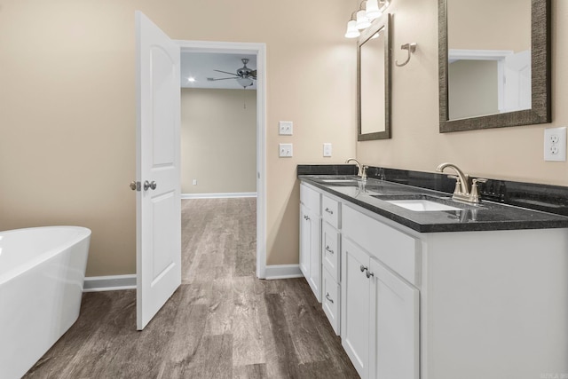 bathroom with a bath, wood-type flooring, vanity, and ceiling fan