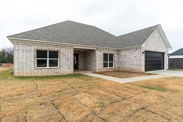 view of front of home with a garage and a front lawn