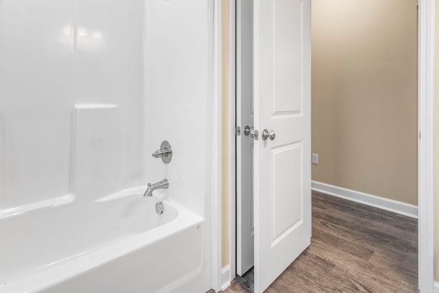 bathroom with hardwood / wood-style floors and  shower combination