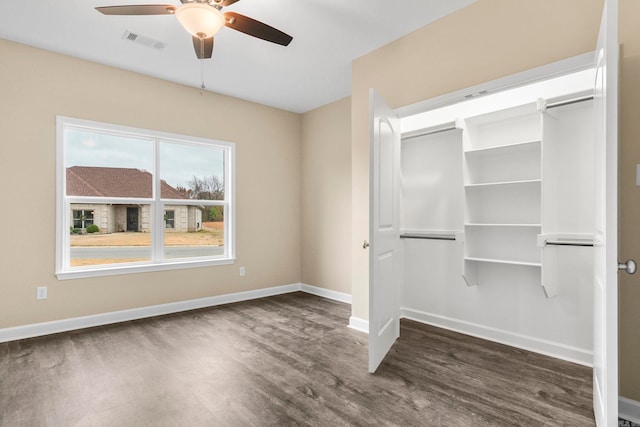 unfurnished bedroom with ceiling fan, a closet, and dark hardwood / wood-style floors