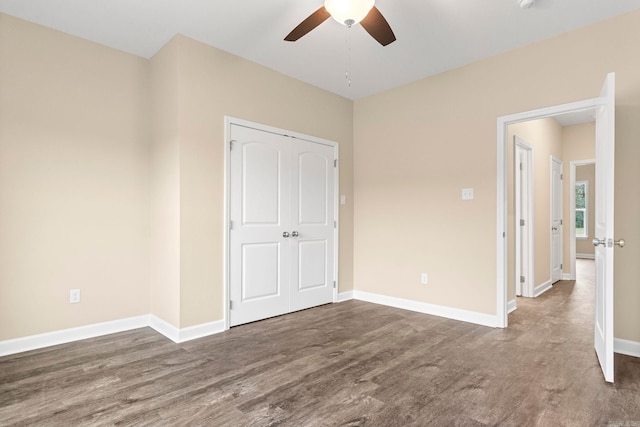 unfurnished bedroom with a closet, ceiling fan, and dark wood-type flooring