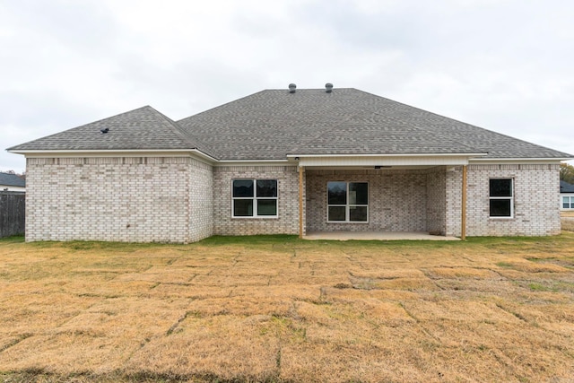 back of house with a lawn and a patio area