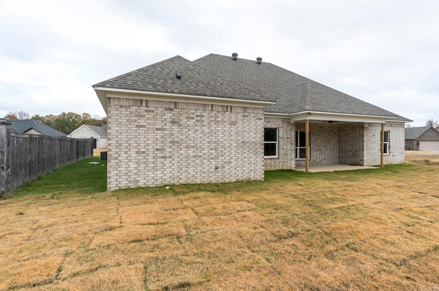 rear view of property featuring a patio area and a yard