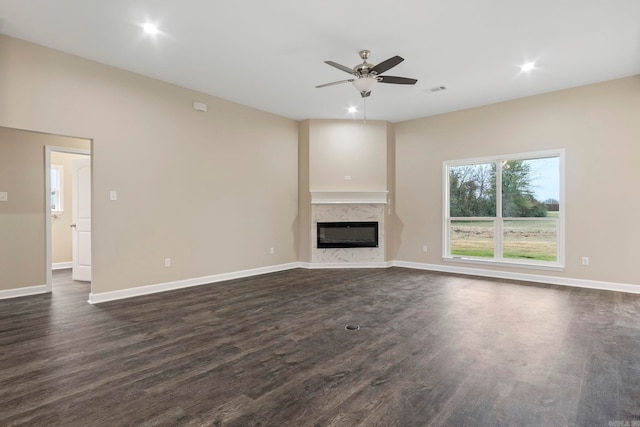 unfurnished living room featuring ceiling fan, dark hardwood / wood-style flooring, and a high end fireplace