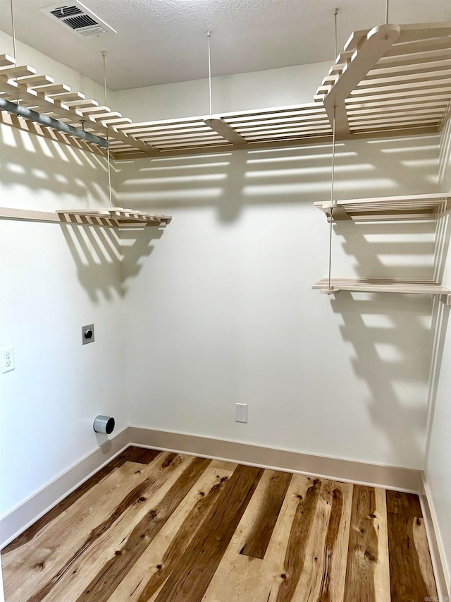 washroom featuring hardwood / wood-style flooring and hookup for an electric dryer