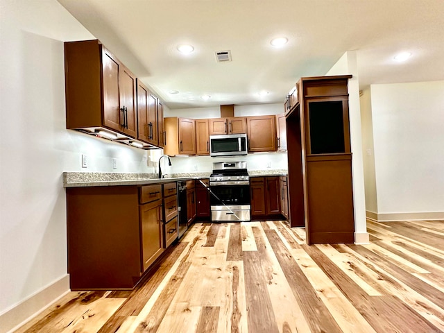 kitchen featuring stainless steel appliances and light hardwood / wood-style flooring