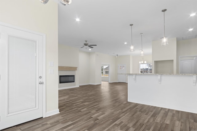 unfurnished living room featuring ceiling fan and dark hardwood / wood-style floors