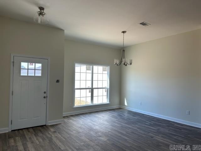 entryway featuring dark hardwood / wood-style flooring and a chandelier