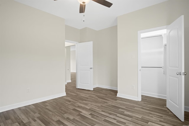 unfurnished bedroom featuring ceiling fan, dark wood-type flooring, and a closet