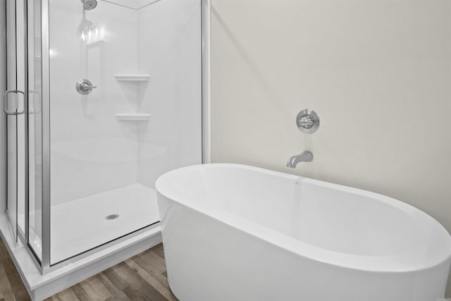 bathroom featuring hardwood / wood-style flooring and shower with separate bathtub