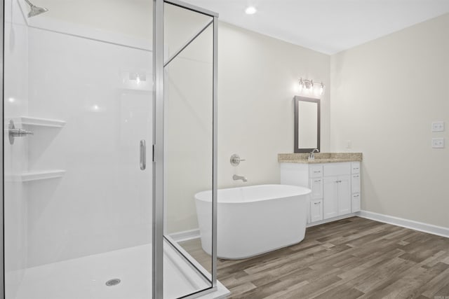 bathroom with vanity, wood-type flooring, and independent shower and bath