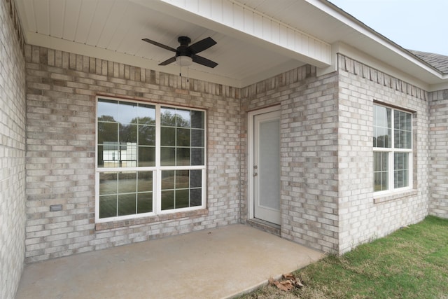 entrance to property with ceiling fan and a patio area