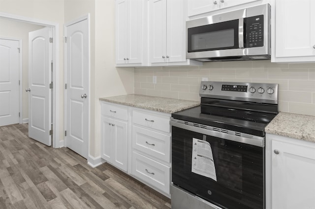 kitchen featuring white cabinets, stainless steel appliances, and light hardwood / wood-style flooring