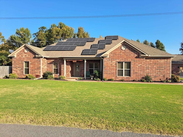 view of front of house with a front lawn and solar panels