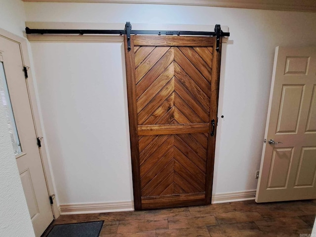 interior space with a barn door and dark wood-type flooring