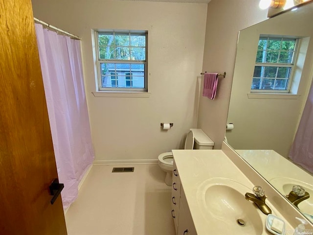 bathroom featuring vanity, a wealth of natural light, and toilet