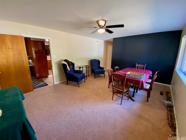 carpeted dining space with ceiling fan