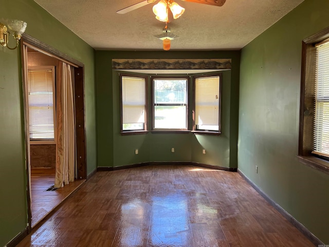 empty room featuring a textured ceiling, hardwood / wood-style flooring, and ceiling fan