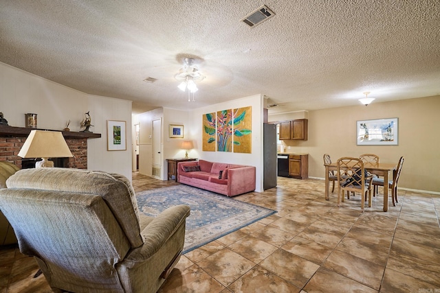 living room featuring ceiling fan, a textured ceiling, and a fireplace