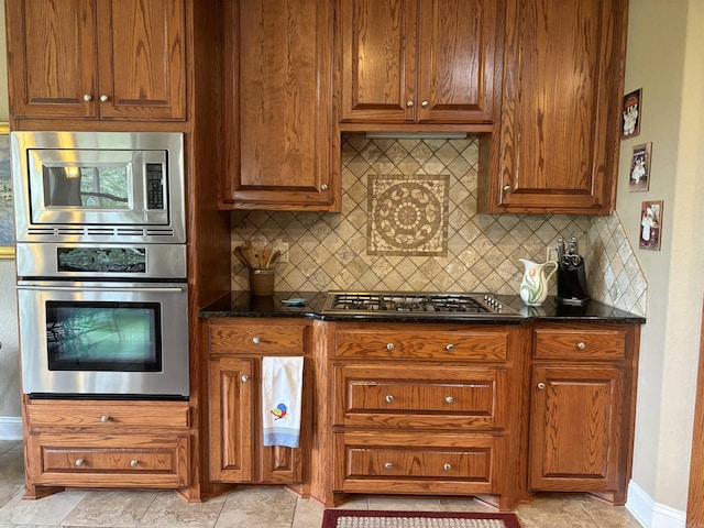 22 Alta Way, Hot Springs Village, AR 71909 - kitchen featuring stainless steel appliances, backsplash, baseboards, brown cabinetry, and dark stone counters
