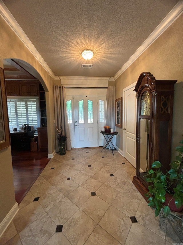 foyer featuring crown molding and a textured ceiling