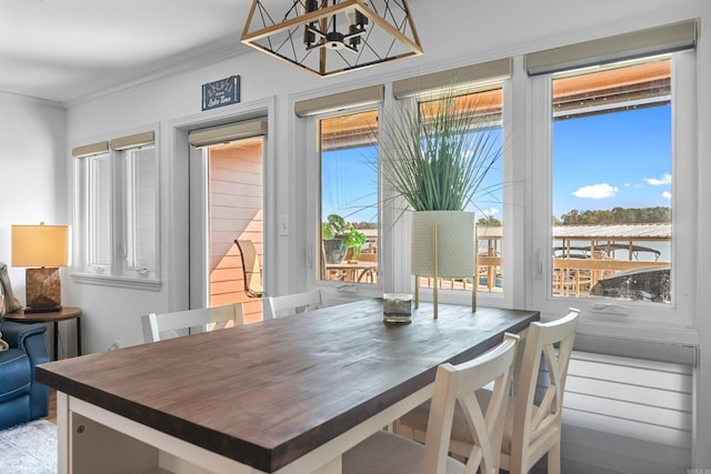 dining room with ornamental molding, a notable chandelier, and a wealth of natural light