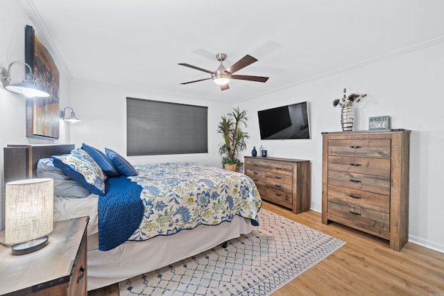 bedroom featuring ceiling fan, ornamental molding, and hardwood / wood-style floors