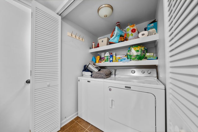 laundry room with dark tile patterned floors and washing machine and dryer