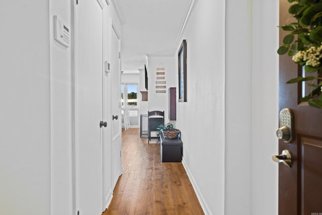 corridor featuring ornamental molding and hardwood / wood-style floors