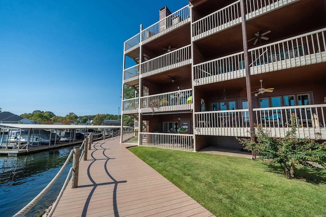 exterior space with a water view, a yard, and a balcony