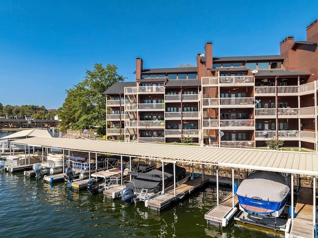 view of dock with a balcony and a water view