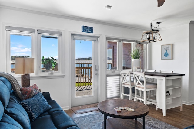 living room featuring ceiling fan with notable chandelier, ornamental molding, hardwood / wood-style floors, and a wealth of natural light