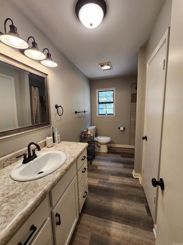 bathroom with a shower with curtain, vanity, toilet, and hardwood / wood-style flooring