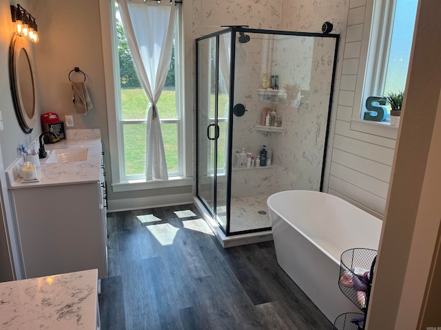 bathroom with shower with separate bathtub, hardwood / wood-style flooring, and vanity