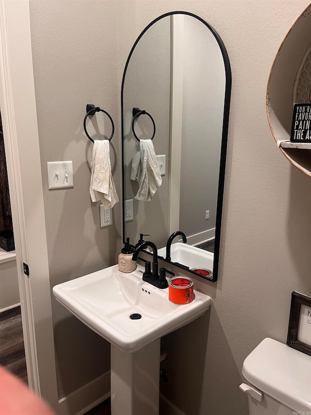 bathroom featuring wood-type flooring, sink, and toilet