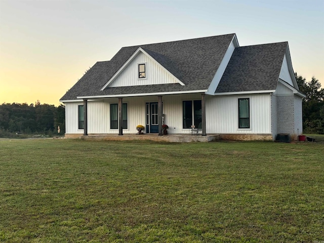 modern farmhouse style home featuring a yard and covered porch